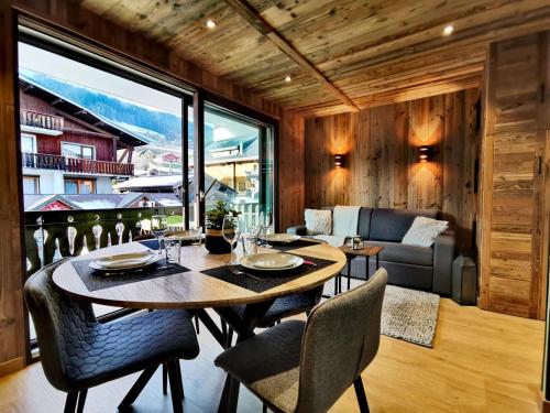une salle à manger avec une table, des chaises et un canapé dans l'établissement Résidence Eden Roc I - Très beau studio, rénové et pratique d'utilisation MAE-1303, aux Gets