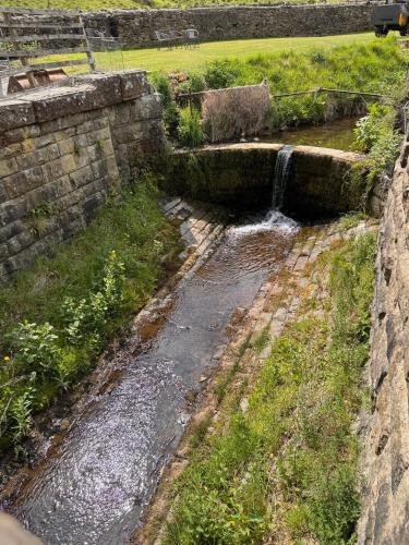 a stream of water coming out of a stone wall at Wend Gardens Studio Carleton Skipton Pet Friendly in Skipton