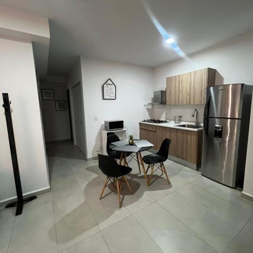 a kitchen with a table and chairs and a refrigerator at Blue Mazatlán in Mazatlán