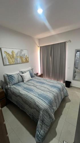 a bedroom with a bed with a blue comforter at Blue Mazatlán in Mazatlán