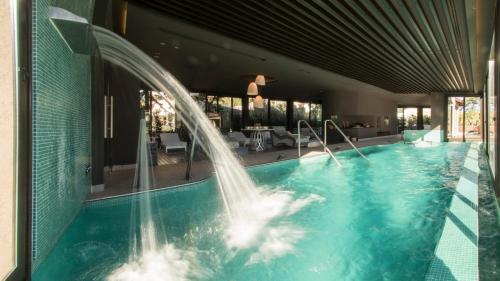 a water fountain in a swimming pool at Ville Saint Germain Apart Hotel & Spa in Carilo