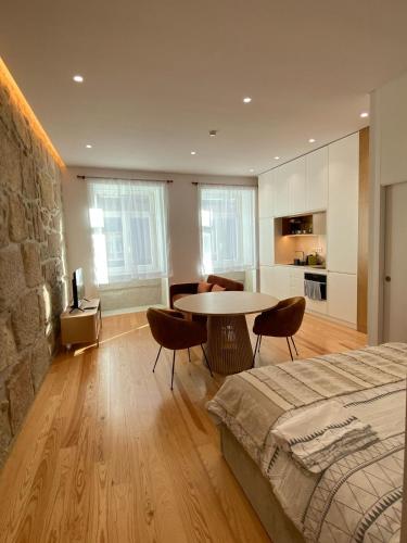 a bedroom with a bed and a table and a kitchen at Porto Suites in Porto