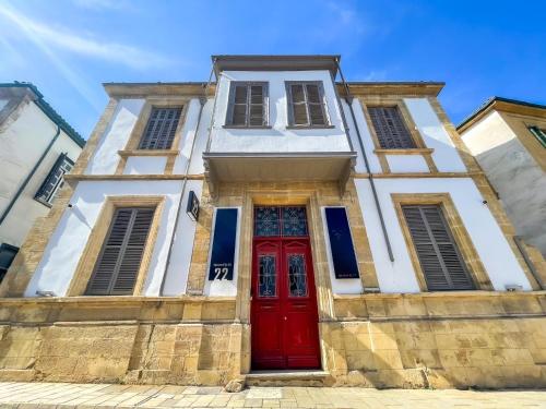 a building with a red door on a street at 22 Yedia North Nicosia Turkish Side in Nicosia