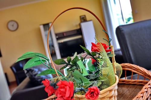 a wicker basket with red flowers on a table at Apartments Soso in Kotor