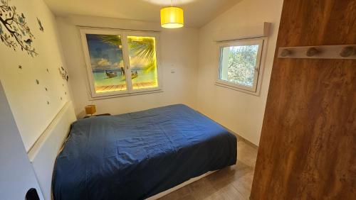 une chambre avec un lit bleu et une fenêtre dans l'établissement Au cœur du Luberon, à Cadenet