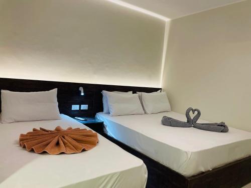 two beds in a room with towels on them at Rivera Apartment in Cairo