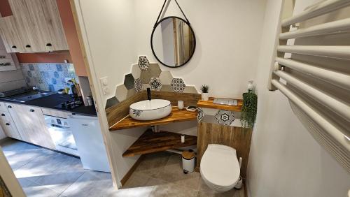 une salle de bain avec un lavabo, des toilettes et un miroir dans l'établissement Au cœur du Luberon, à Cadenet