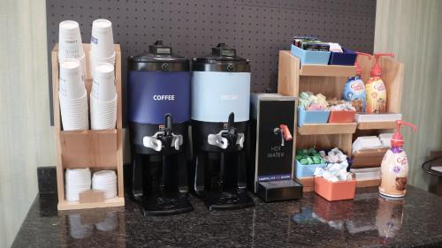 a counter top with a group of cups and bottles at Holiday Inn Express & Suites Morton Peoria Area by IHG in Morton