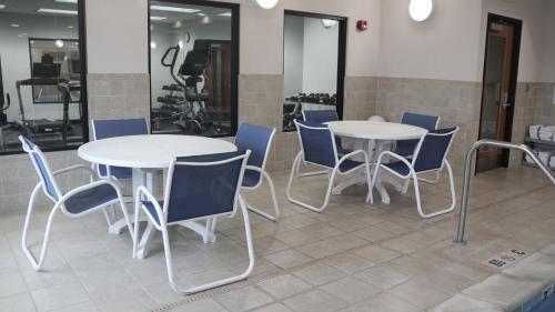 two tables and blue chairs in a room at Holiday Inn Express & Suites Morton Peoria Area by IHG in Morton