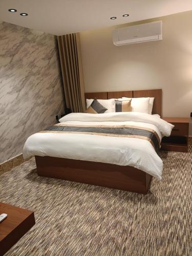 a large bedroom with a large bed with white sheets at Medad Apartments Al Hamra in Al Khobar