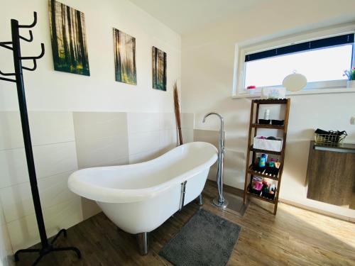 Una bañera blanca en un baño con ventana. en Modern House in Spielberg near Red Bull Ring, en Spielberg