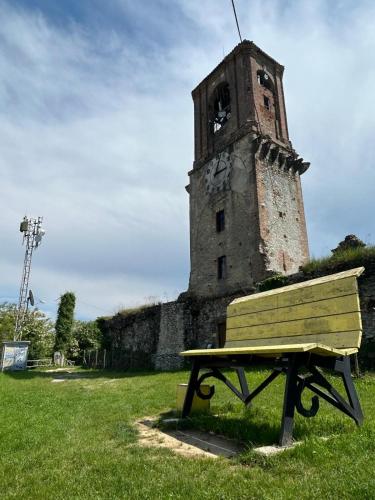 a bench sitting in front of a tower with a clock at Casa Leopoldo in Ceva