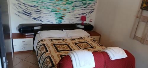 a bedroom with a bed with a painting on the wall at B&B La Foglietta in Paganica