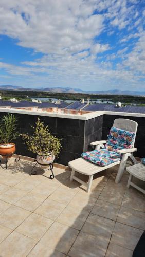 un patio con un banco y 2 sillas en el techo en Apartamento Carabassi, en Alicante