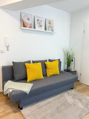ein graues Sofa mit gelben Kissen im Wohnzimmer in der Unterkunft Modernisierte Ruheoase mit Parkplatz in Osnabrück
