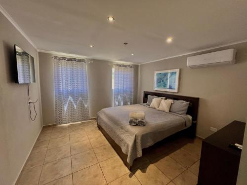 a bedroom with a bed and two windows at The Gold Vacation Villa in Santa Cruz
