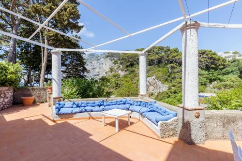 a couch on a patio with a view of the ocean at La Perla Marina Suite in Capri