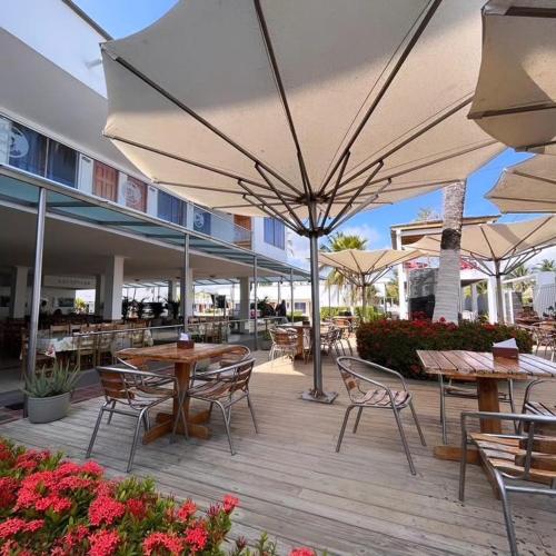 an outdoor patio with tables and chairs and umbrellas at Hotel La Fragata in Coveñas