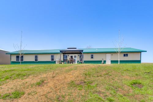 a large building with a green roof on a field at Lakefront Family Home with Boat Dock in Underwood in Battle Lake