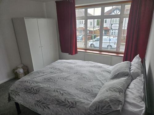 a bed sitting in a bedroom with a window at 4-Bedroom Retreat in Staines with Private Garden & Easy Parking in Staines