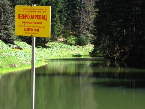 a sign in the middle of a body of water at Šumska vila in Šljivovica