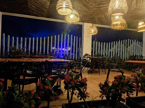 a dining room with tables and chairs and a blue wall at Hotel La Fragata in Coveñas