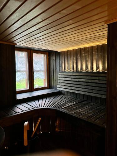 an empty room with two windows and a bed at Wooden house in Käpylä in Helsinki