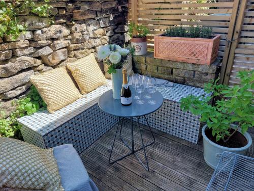 a table with wine bottles and glasses on a patio at Sett Cottage, Hayfield in Hayfield