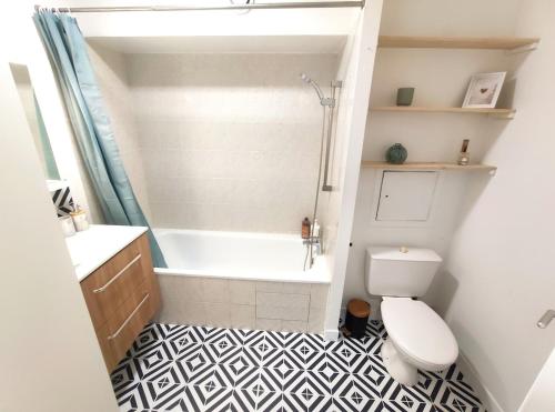 a bathroom with a tub and a toilet and a sink at DisneyLand - Paris 20 min - Parking - 6 personnes in Chelles