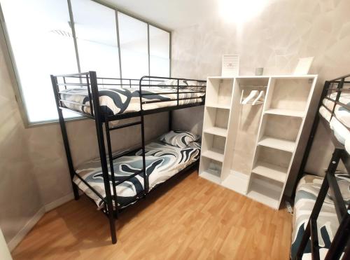 a room with two bunk beds and a window at DisneyLand - Paris 20 min - Parking - 6 personnes in Chelles