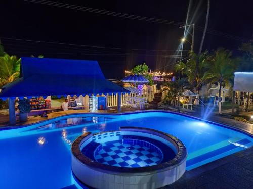 a swimming pool at night with a resort at Hotel La Fragata in Coveñas