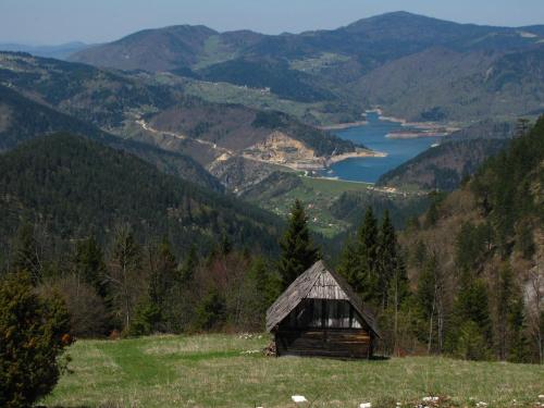 an old barn on a hill overlooking a lake at Šumska vila in Šljivovica