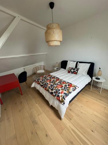 une chambre avec un lit avec une couette dessus dans l'établissement Superbe duplex T4, au coeur de Batz, tout à pied !, à Batz-sur-Mer