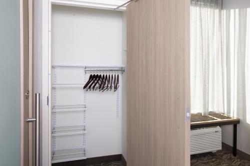 a walk in closet with a glass door at SpringHill Suites by Marriott Raleigh Garner in Garner