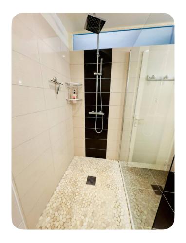 une douche avec une porte vitrée dans une salle de bain dans l'établissement Vacances en Famille face mer - plage à Pontaillac, à Royan