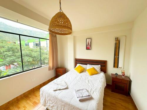Un dormitorio con una cama y una ventana grande. en Hospedaje Maranura Quillabamba, en Maranura