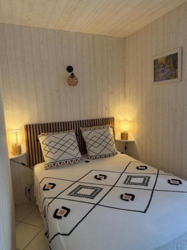 a bedroom with a bed with a black and white comforter at Appartement tout confort pieds dans l'eau avec vue imprenable , pause nature in Anthy