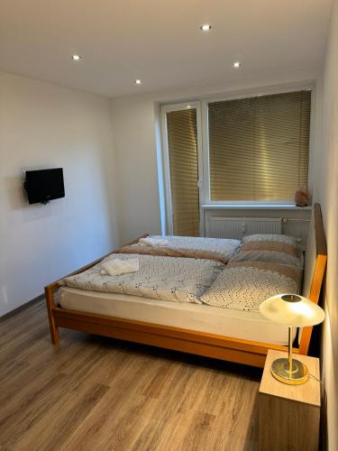 a bedroom with a bed with a window and a table at Bulharská Trojizbový apartmán in Košice