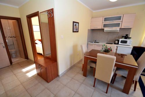 a kitchen and a dining room with a table and a kitchen at Apartments Soso in Kotor