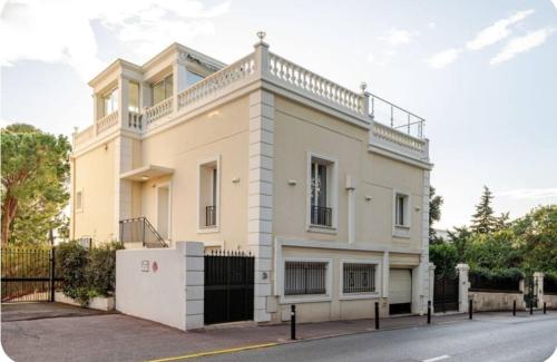 une maison blanche avec une clôture devant dans l'établissement Luxurious Apartment Cannes city center five minutes from beach, à Cannes