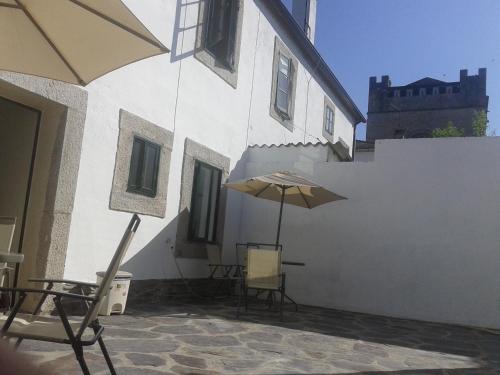 a patio with a table and an umbrella on a building at Pensión Mar in Portomarin