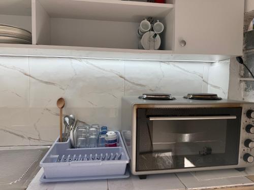 a kitchen with a microwave with a tray next to it at Villa Gjoka in Velipojë