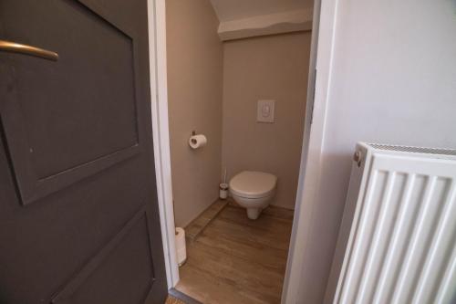 a small bathroom with a toilet and a door at La Parenthèse Cosy Jacuzzi & Charme in Aubenas