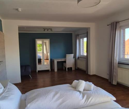 a bedroom with a white bed and a table at Up de Sülten in Bergen
