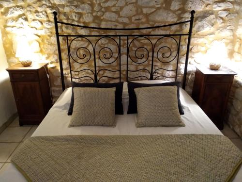 - une chambre avec un lit noir et 2 tables de chevet dans l'établissement Le Vignal, à Monflanquin