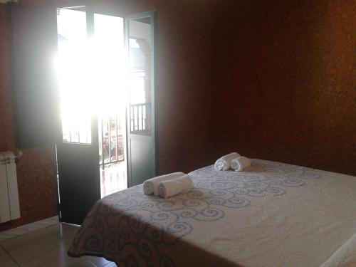 a bedroom with a bed with two towels on it at Pensión Mar in Portomarin