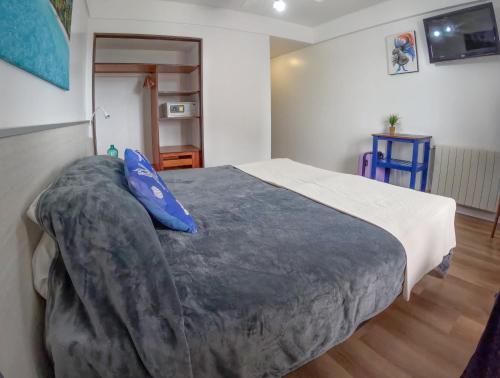 a bedroom with a large bed with a blue pillow at Hotel Solmar in San Clemente del Tuyú