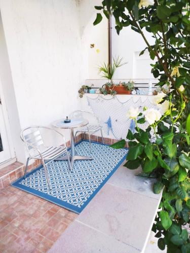 a patio with a table and chairs on a rug at Apartmani Ruža in Zaton