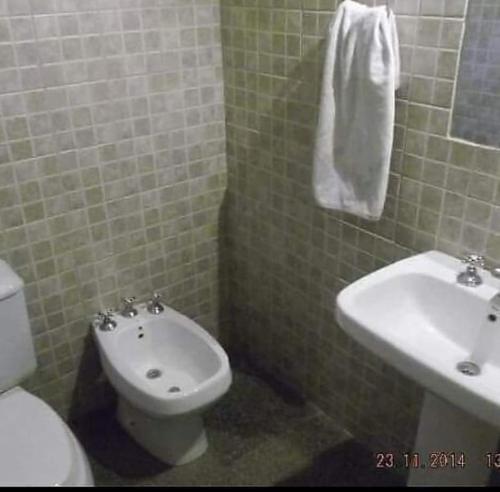 a bathroom with a white toilet and a sink at La casita in Mendoza