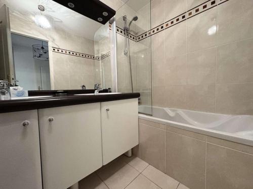 une salle de bain avec un lavabo, une baignoire et une douche dans l'établissement Résidence Laétitia - LA BAULE - PLAGE ET COMMERCES MAE-9563, à La Baule